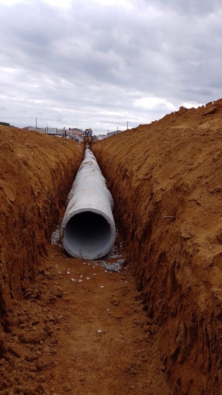 Implantação de rede de drenagem no loteamento KDB com tubulações de concreto, escavação e elementos complementares.