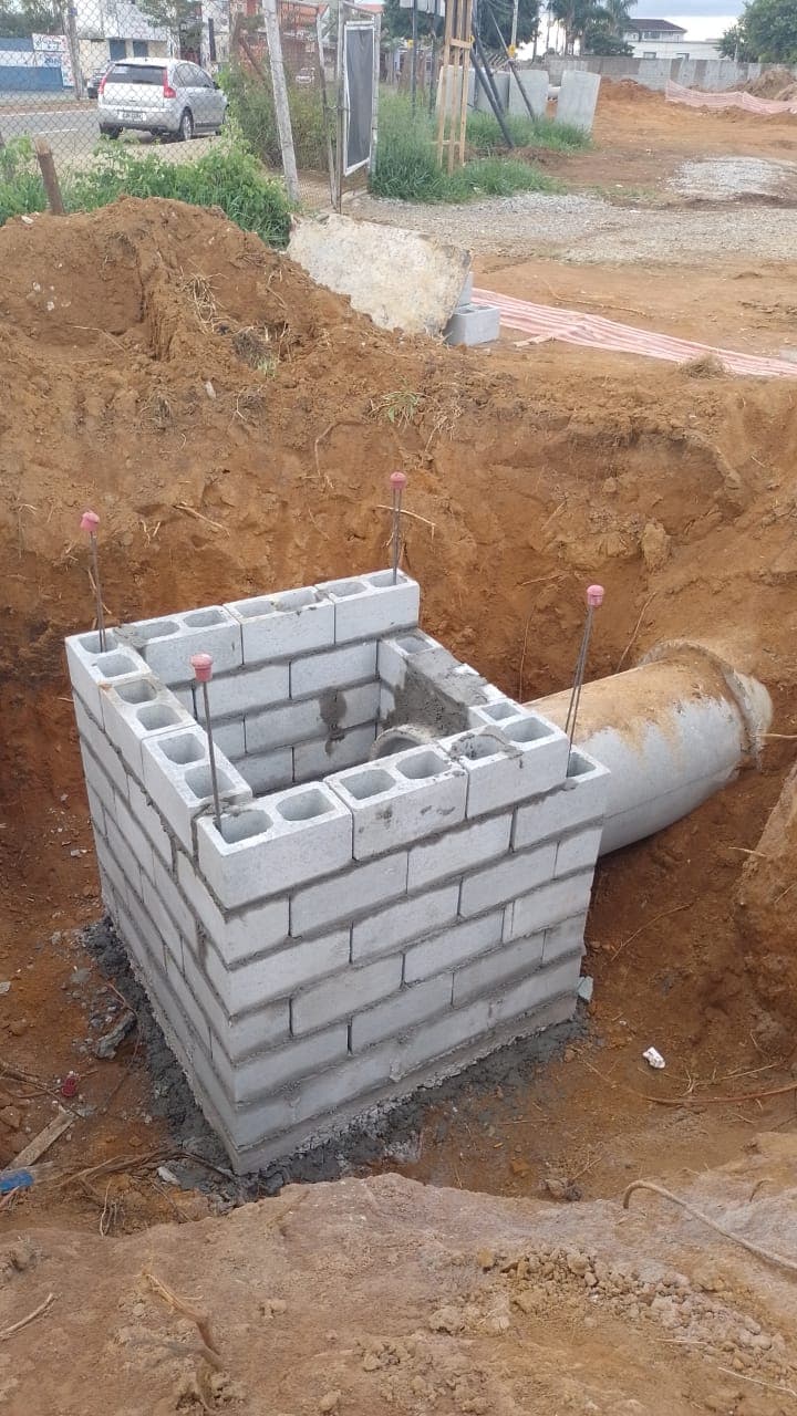 Implantação de rede de drenagem no loteamento KDB com tubulações de concreto, escavação e elementos complementares.